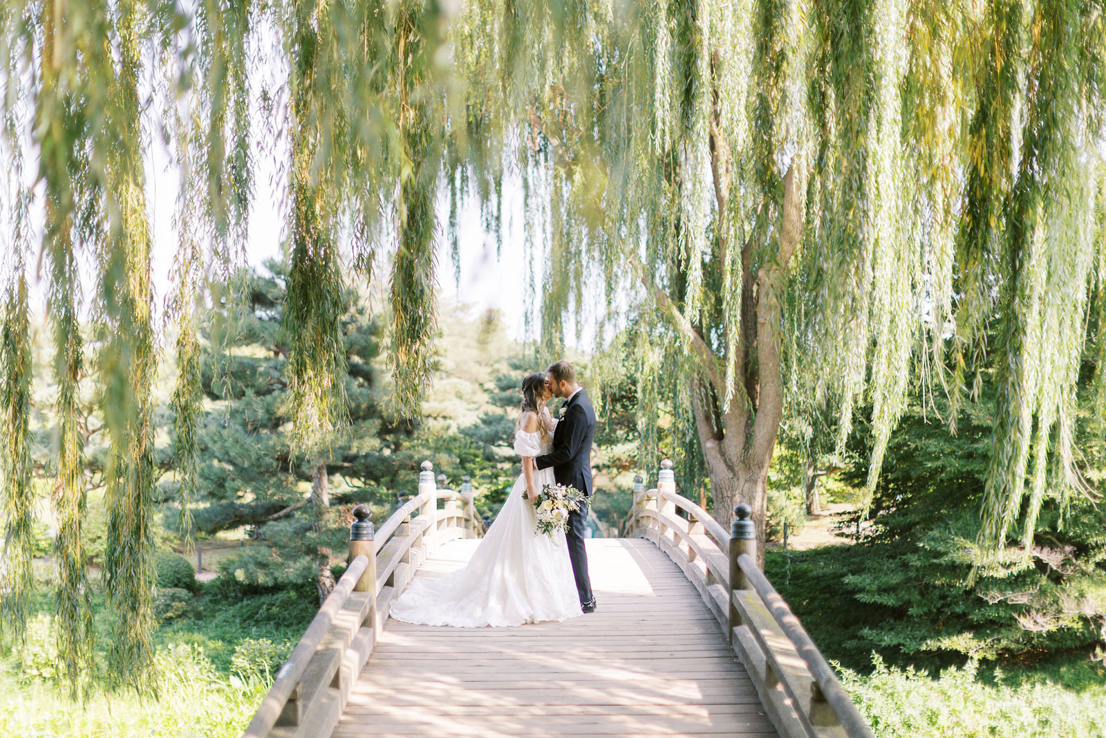 Bride and groom standing on a bridge surrounded by greenery at a wedding venue in Chicago