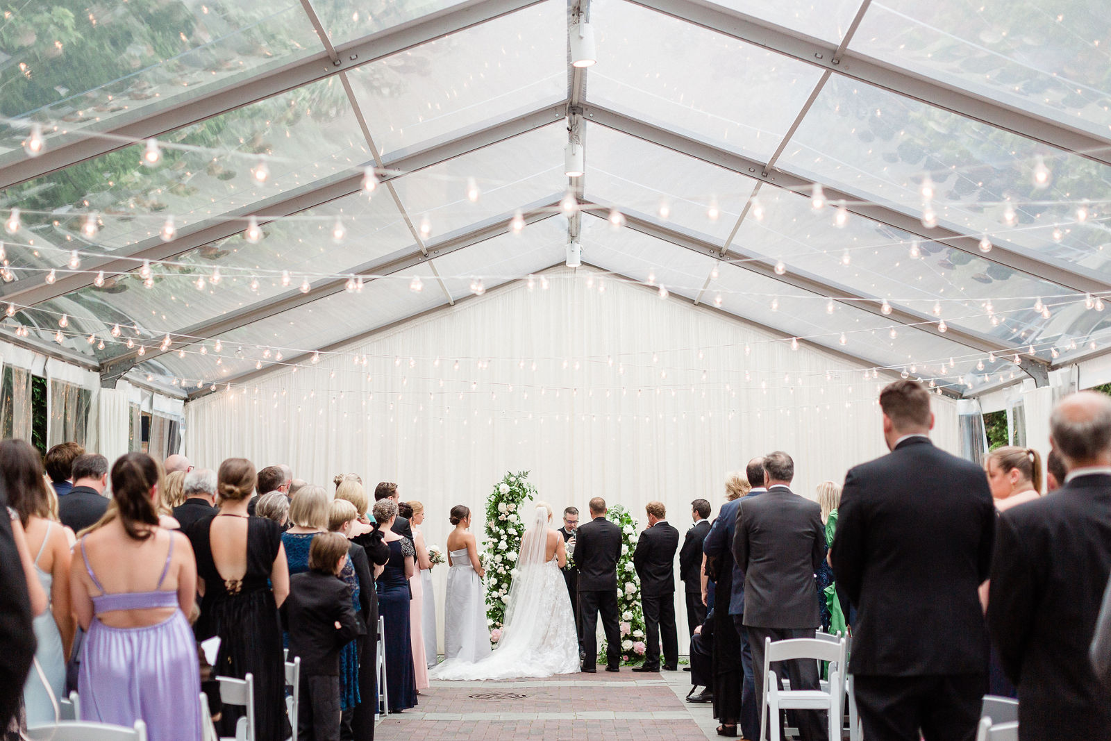 Outdoor tent ceremony setup with guests seated at a beautiful wedding venue in Chicago suburbs