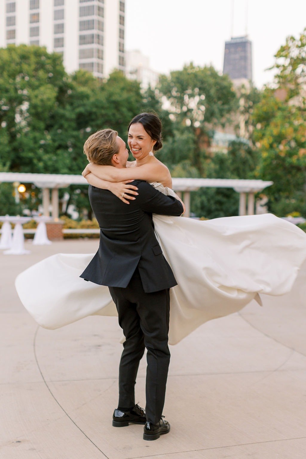 Groom spinning bride outdoors during golden hour after they get married in Chicago