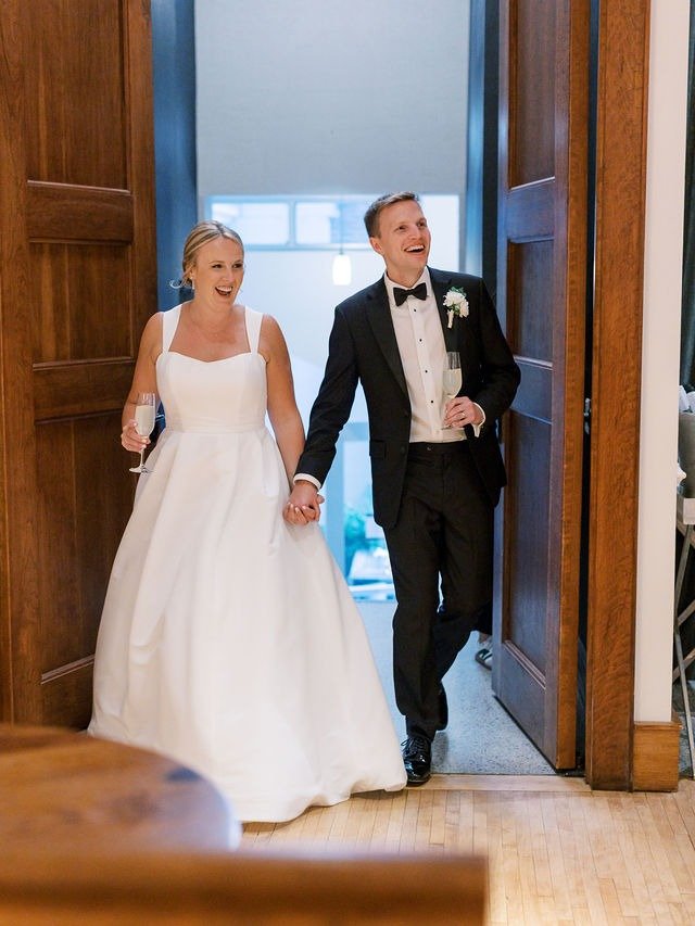 Newlyweds entering reception together with champagne as a result of planning a wedding in Chicago Illinois