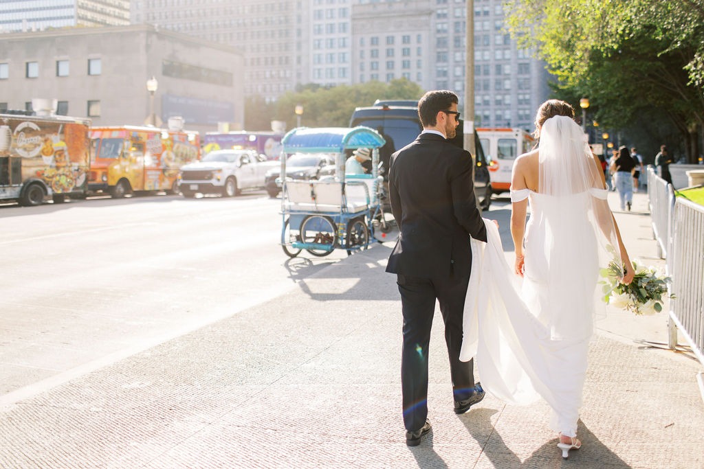 bride and groom walking down the street for portraits after their wedding ceremony at the top wedding venue in chicago