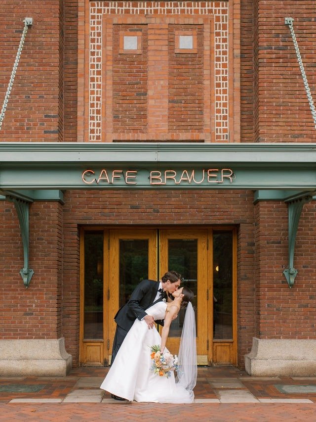 Bride and groom kissing outside Cafe Brauer, a popular choice for wedding venues in downtown Chicago