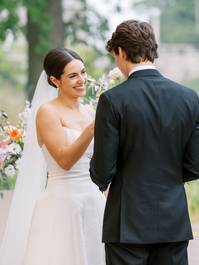 bride looking at groom, smiling, during their wedding ceremony at one of the best outdoor wedding venues in the chicago area