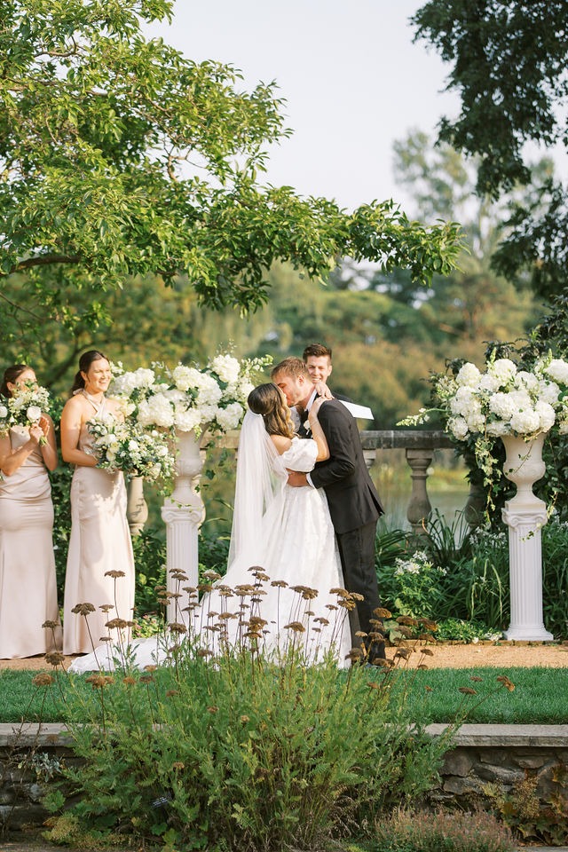 bride and groom kissing during their ceremony held at one of the best outdoor wedding venues in the chicago area